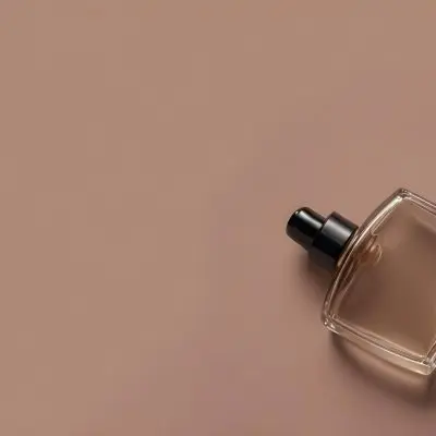 A Perfume Bottle With A Black Spray Nozzle On A Plain Black Background The Bottle Is Clear And Partially Filled With Liquid 16