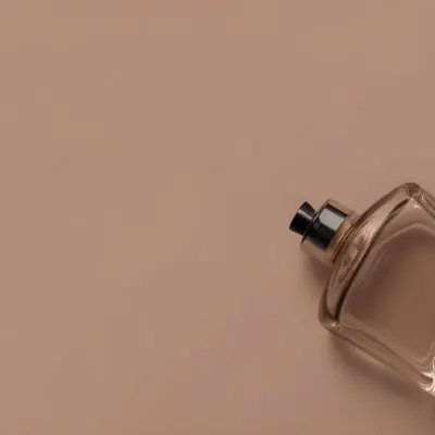 A Perfume Bottle With A Black Spray Nozzle On A Plain Black Background The Bottle Is Clear And Partially Filled With Liquid 36 C89c