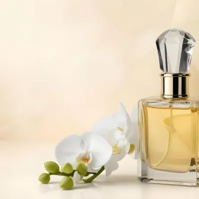 A Perfume Bottle With A Crystal Cap Next To A White Orchid Flower The Background Is A Soft Beige Color With Subtle Lighting 9 1387