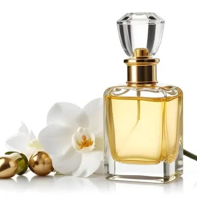 A Perfume Bottle With A Golden Cap Filled With Golden Liquid Next To A White Orchid On A White Background 25 Abc5