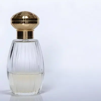 A Perfume Bottle With A Transparent Cap Transparent Glass With Vertical Stripes Half Full Of Transparent Liquid In A White Background 2 18e0