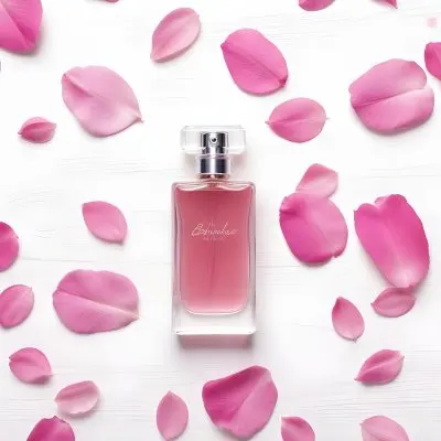A Perfume Bottle With Pink Liquid Surrounded By Pink Flower Petals On A White Wooden Surface Elegant Luxury Beauty Fashion Floral Fragrance 34 01b2