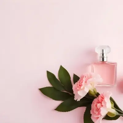 A Perfume Bottle With Pink Liquid Two Pink Carnations And Green Leaves On A Pink Background 21 13a1