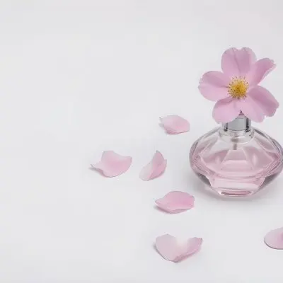 A Pink Flower Inside A Glass Perfume Bottle With Some Petals Around It On A White Background 60 2c5a