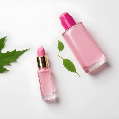 A Pink Glass Bottle And A Pink Lipstick Tube On A White Background With A Green Leaf 12 1ecf