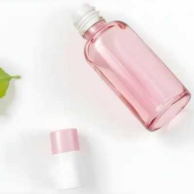 A Pink Glass Bottle And A Pink Lipstick Tube On A White Background With A Green Leaf 5 Fdca