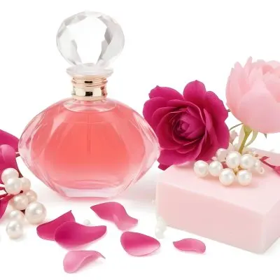 A Pink Perfume Bottle With A Glass Stopper A White Flower A White Soap And Some Pearls On A Pink Background 31 106e