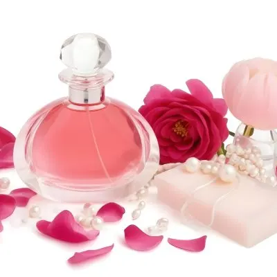 A Pink Perfume Bottle With A Glass Stopper A White Flower A White Soap And Some Pearls On A Pink Background 33 A69b