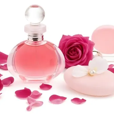 A Pink Perfume Bottle With A Glass Stopper A White Flower A White Soap And Some Pearls On A Pink Background 45 3f6b