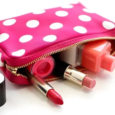 A Pink Polka Dot Cosmetic Bag With Various Makeup Items Inside Including A Red Lipstick And A Small Bottle A Blue Striped Cosmetic Bag With Various Makeup Items Inside Including A Nude Lipstick And A Small Bottl 8 0322