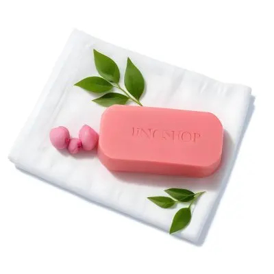 A Pink Soap Bar With Green Leaves On A White Towel Surrounded By Blue Flowers In Bright Sunlight 38 7185