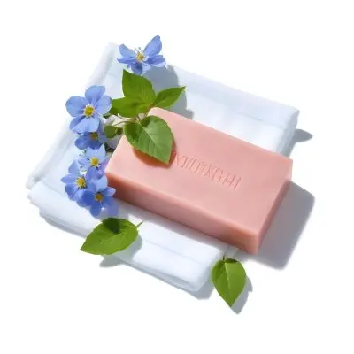 A Pink Soap Bar With Green Leaves On A White Towel Surrounded By Blue Flowers In Bright Sunlight 68 05e4