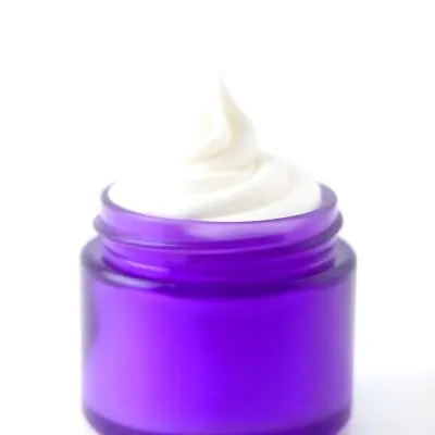 A Purple Jar With A Swirl Of White Cream Coming Out Of It Isolated On A White Background Product Photography Studio Shot 7 F93c