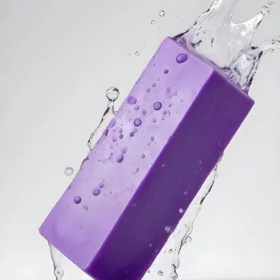 A Purple Soap Bar Falling Into The Water With Bubbles In A White Background 10 4f33