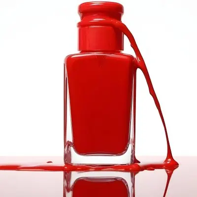 A Red Nail Polish Bottle With Nail Polish Dripping Down The Side On A Red Background 11 7999