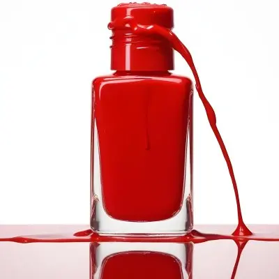 A Red Nail Polish Bottle With Nail Polish Dripping Down The Side On A Red Background 11 985a