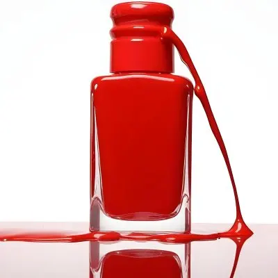 A Red Nail Polish Bottle With Nail Polish Dripping Down The Side On A Red Background 12 7e9f