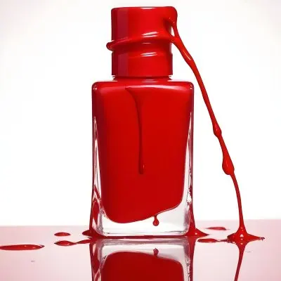 A Red Nail Polish Bottle With Nail Polish Dripping Down The Side On A Red Background 18 E335