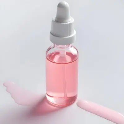 A Small Glass Bottle With A White Cap And A White Dropper Filled With A Pink Liquid On A White Background 8 37dd