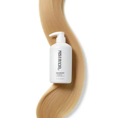 A White Bottle Of Shampoo With A Pump Wrapped In A Strand Of Long Blonde Hair On A White Background 30 Fa3c