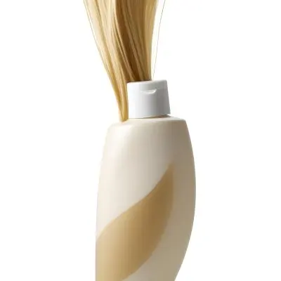 A White Bottle Of Shampoo With A Pump Wrapped In A Strand Of Long Blonde Hair On A White Background 31 B802