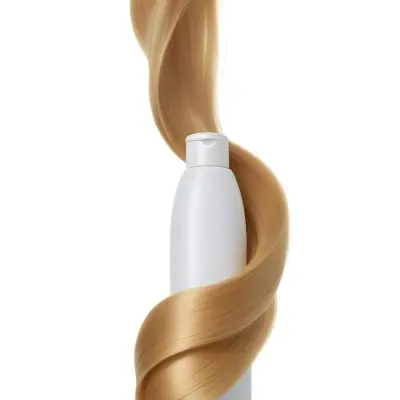 A White Bottle Of Shampoo With A Pump Wrapped In A Strand Of Long Blonde Hair On A White Background 35 B9f3