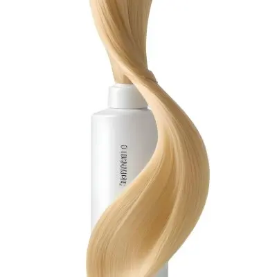 A White Bottle Of Shampoo With A Pump Wrapped In A Strand Of Long Blonde Hair On A White Background 57 5a51