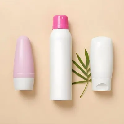 A White Deodorant Bottle With A Pink Cap A White Lotion Bottle And A Green Leaf On A Beige Background 32 7691