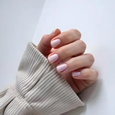 A Woman S Hand With Pale Skin And Short White Nails Wearing A Beige Corduroy Shirt On A White Background 22 1a9c