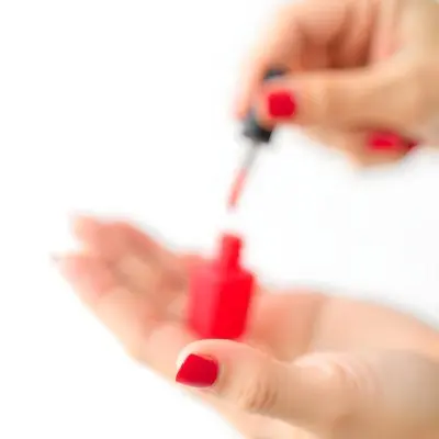 A Woman S Hands With Red Nail Polish One Hand Holding The Brush With A Drop Falling Into The Open Bottle White Background 19 27cb