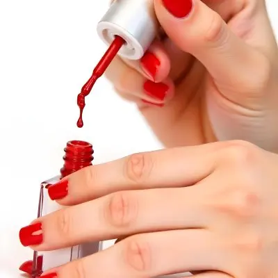 A Woman S Hands With Red Nail Polish One Hand Holding The Brush With A Drop Falling Into The Open Bottle White Background 6 654b