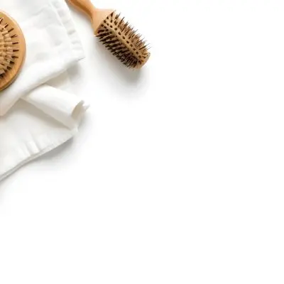 A Wooden Hairbrush A Glass Bottle And A White Towel On A White Background 9 3807