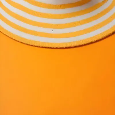 A Yellow And White Striped Hat On An Orange Backgr 7 B48e