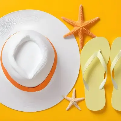 A Yellow Hat A Starfish An White Sunscreen And White Flip Flops On A Orange Background 24 2bf3