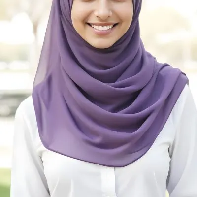 A Young Middle Eastern Woman With Dark Hair Wearing A Purple Hijab And A Light Colored Jacket Smiling In An Outdoor Setting With Trees In The Background 17 F8c7