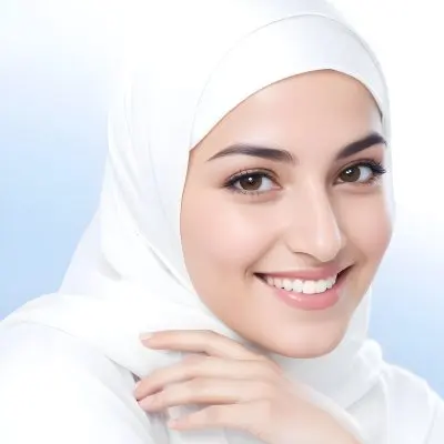 A Young Middle Eastern Woman With Dark Hair Wearing A White Hijab Smiling At The Camera 14 26a7