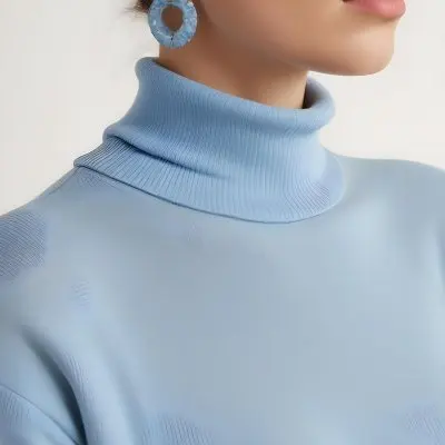 A Young Woman With Long Light Hair Wearing A Light Blue Turtleneck Sweater And Large Round Earrings 7 76d2