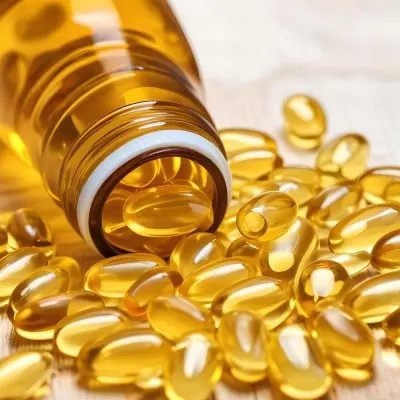 Bottle Of Golden Fish Oil Capsules Spilled On A Wooden Surface 11 3c82