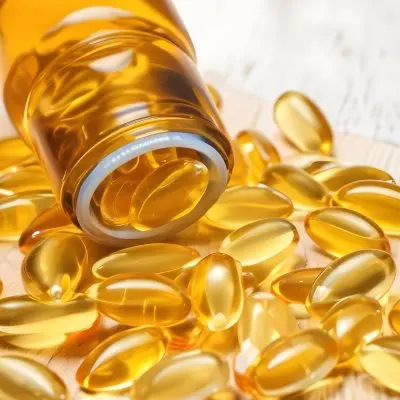 Bottle Of Golden Fish Oil Capsules Spilled On A Wooden Surface 16 Bfc7