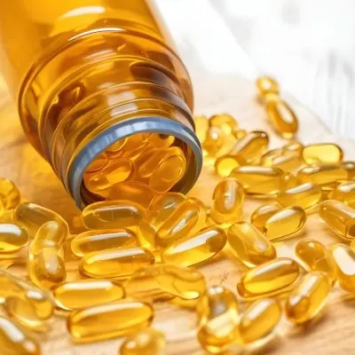 Bottle Of Golden Fish Oil Capsules Spilled On A Wooden Surface 21 0217