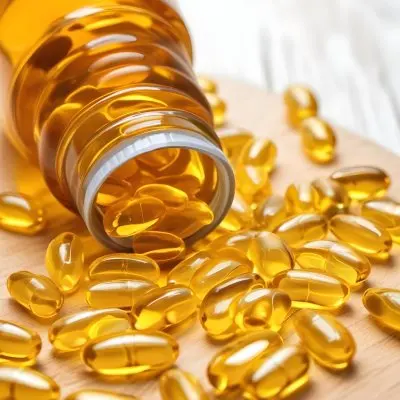 Bottle Of Golden Fish Oil Capsules Spilled On A Wooden Surface 6 86c9