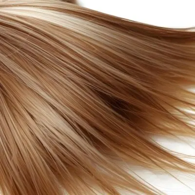 Brown And Blonde Hair Strands With Visible Texture Illuminated By A Bright Light Source Creating Highlights And Shadows Against A Plain White Background 23