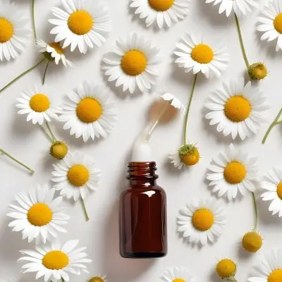 Brown Glass Bottle With Dropper Surrounded By Chamomile Flowers White Background 18 2d96