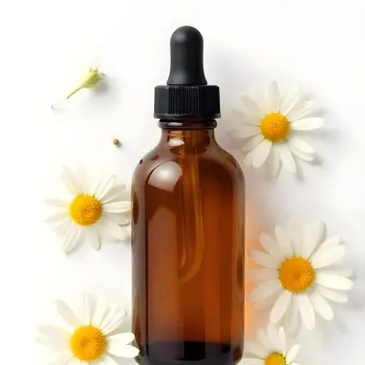 Brown Glass Bottle With Dropper Surrounded By Chamomile Flowers White Background 6 04d6