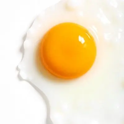 A Fried Egg With A Bright Yellow Yolk And Translucent White On A White Surface Top Down View Studio Lighting Food Photography 33 01cb