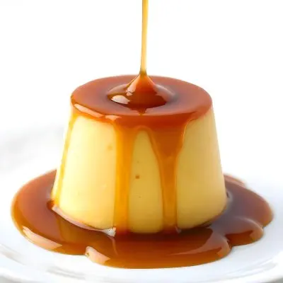 Caramel Flan With Caramel Syrup Being Poured On Top On A White Background 12 Af6f