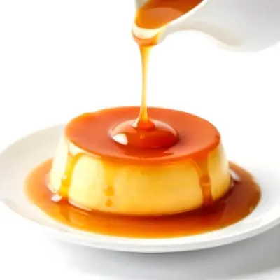Caramel Flan With Caramel Syrup Being Poured On Top On A White Background 29 B36e