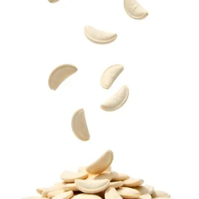 Pumpkin Seeds Falling Into A Pile Of Pumpkin Seeds Isolated On A White Background 26 Bdb3