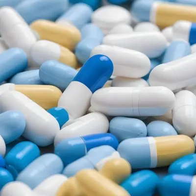 Pile Of Blue White And Yellow Pills And Capsules Pharmaceutical Drugs Medicine Health And Wellness Concept 10 C95e