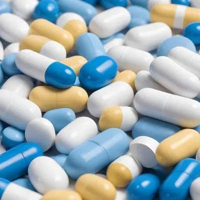 Pile Of Blue White And Yellow Pills And Capsules Pharmaceutical Drugs Medicine Health And Wellness Concept 11 635b